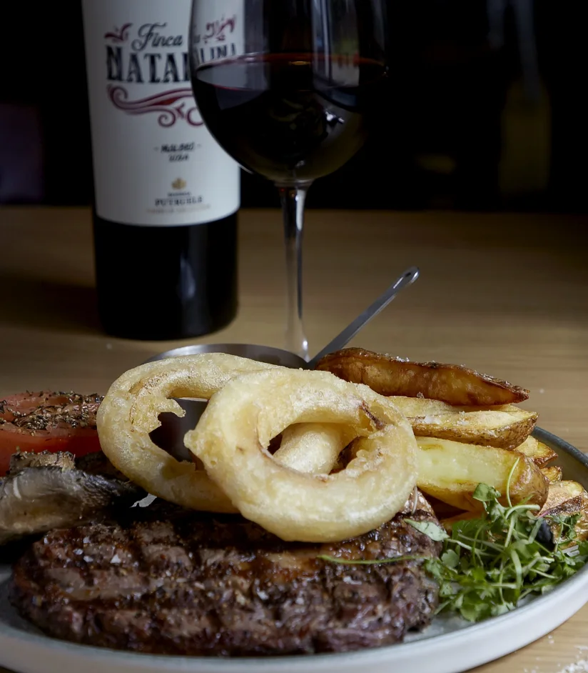 Steak, chips, onion rings and red wine